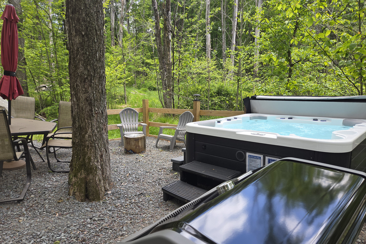 Backyard with hot tub, firepit, weber bbq grill, table with seating