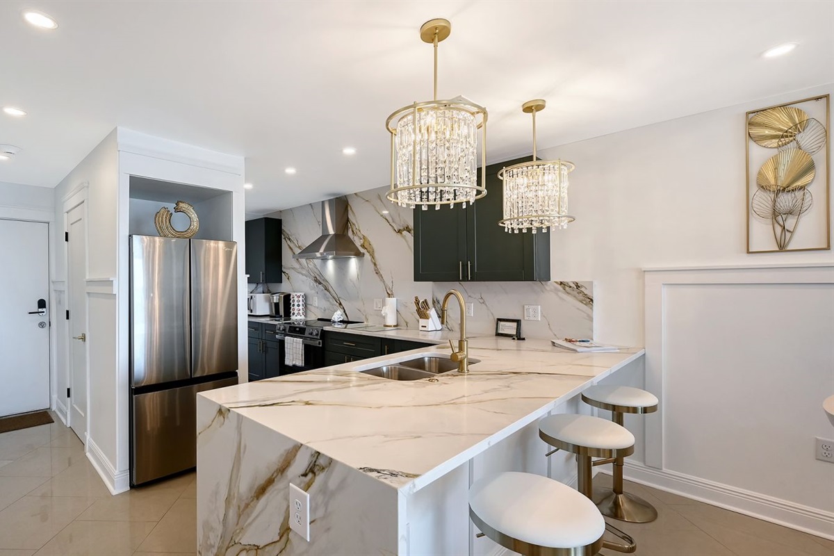Kitchen with oversized quartz counter & bar stools 