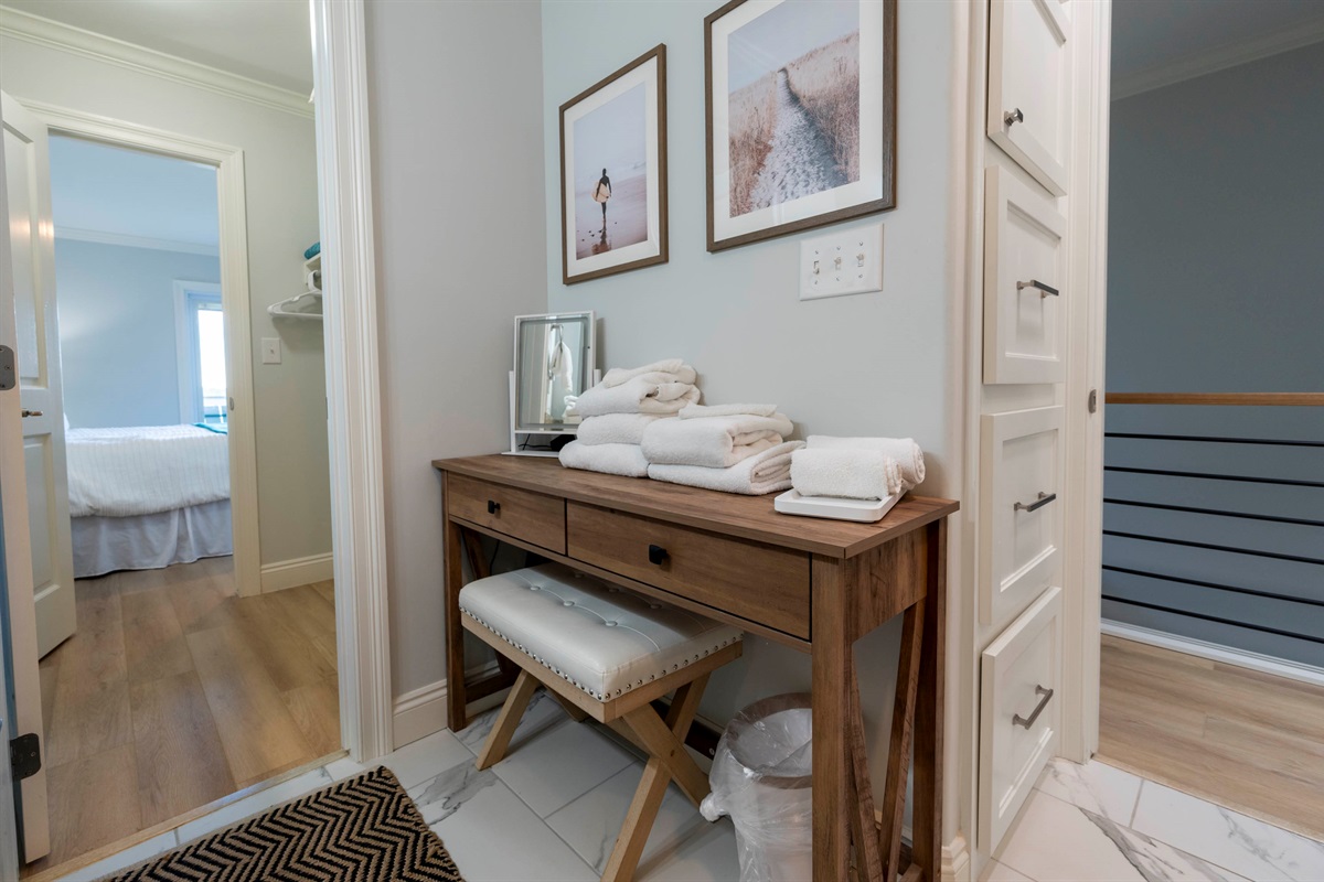 Cozy hallway with a wooden console, soft towels, and inviting wall art.