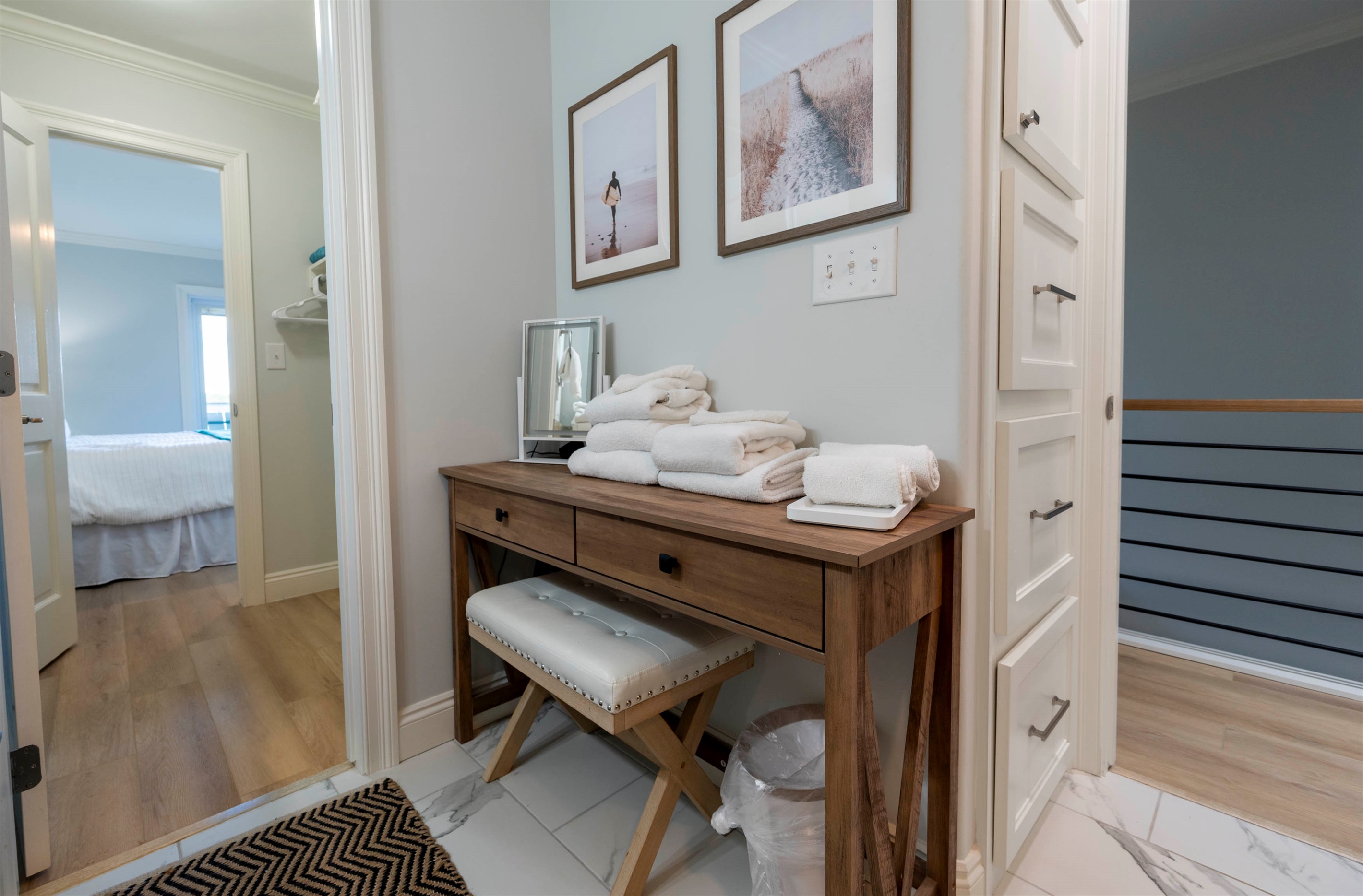 Cozy hallway with a wooden console, soft towels, and inviting wall art.
