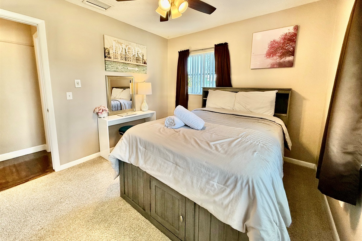 Modern design meets cozy charm in this stylish bedroom, featuring a sleek bed frame, curated artwork, and convenient bedside lighting.
