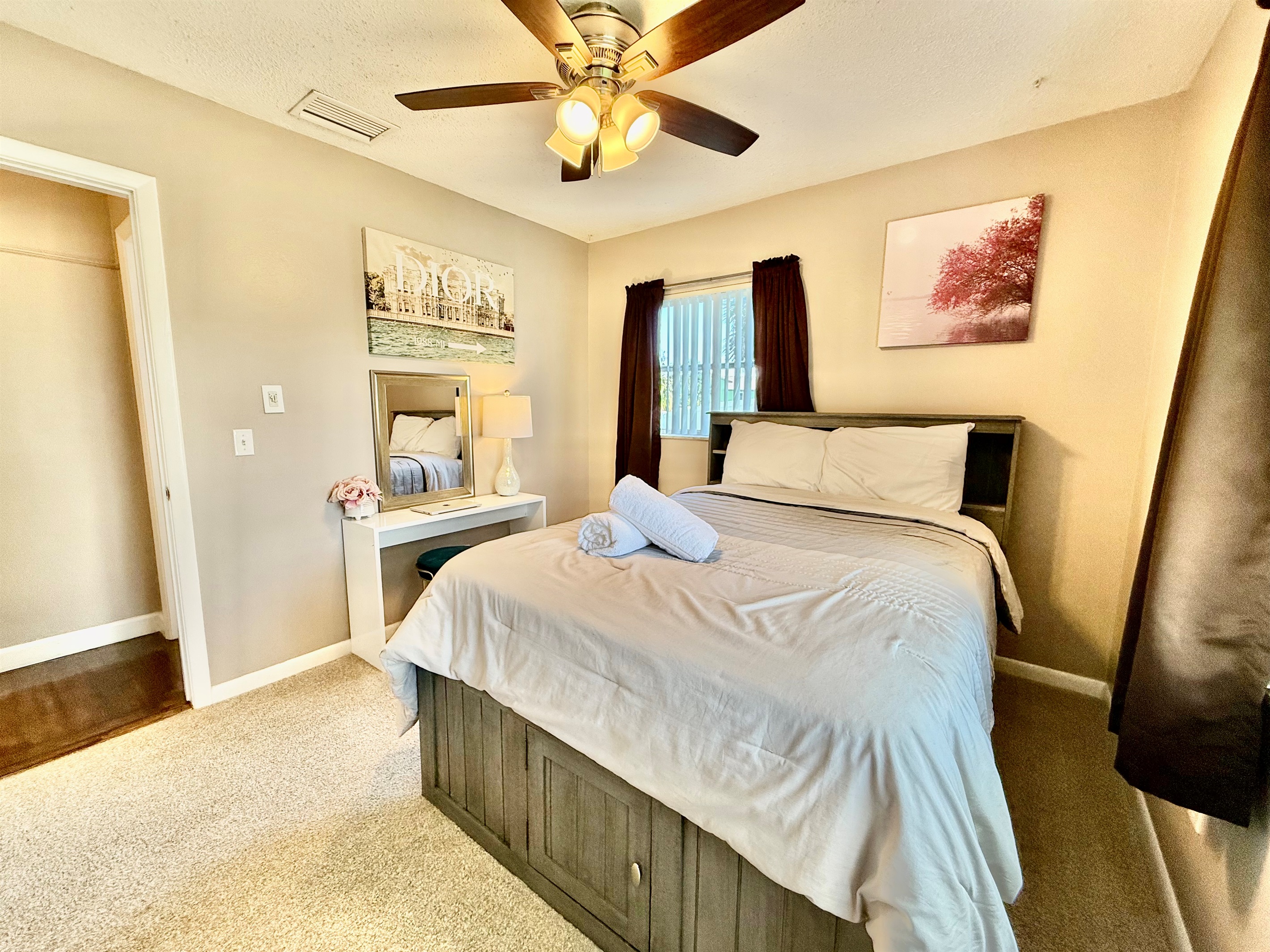 Modern design meets cozy charm in this stylish bedroom, featuring a sleek bed frame, curated artwork, and convenient bedside lighting.