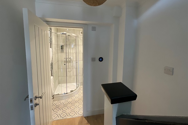 The downstairs shower room.  The smart thermometer on the wall allows guests to boost the heating.