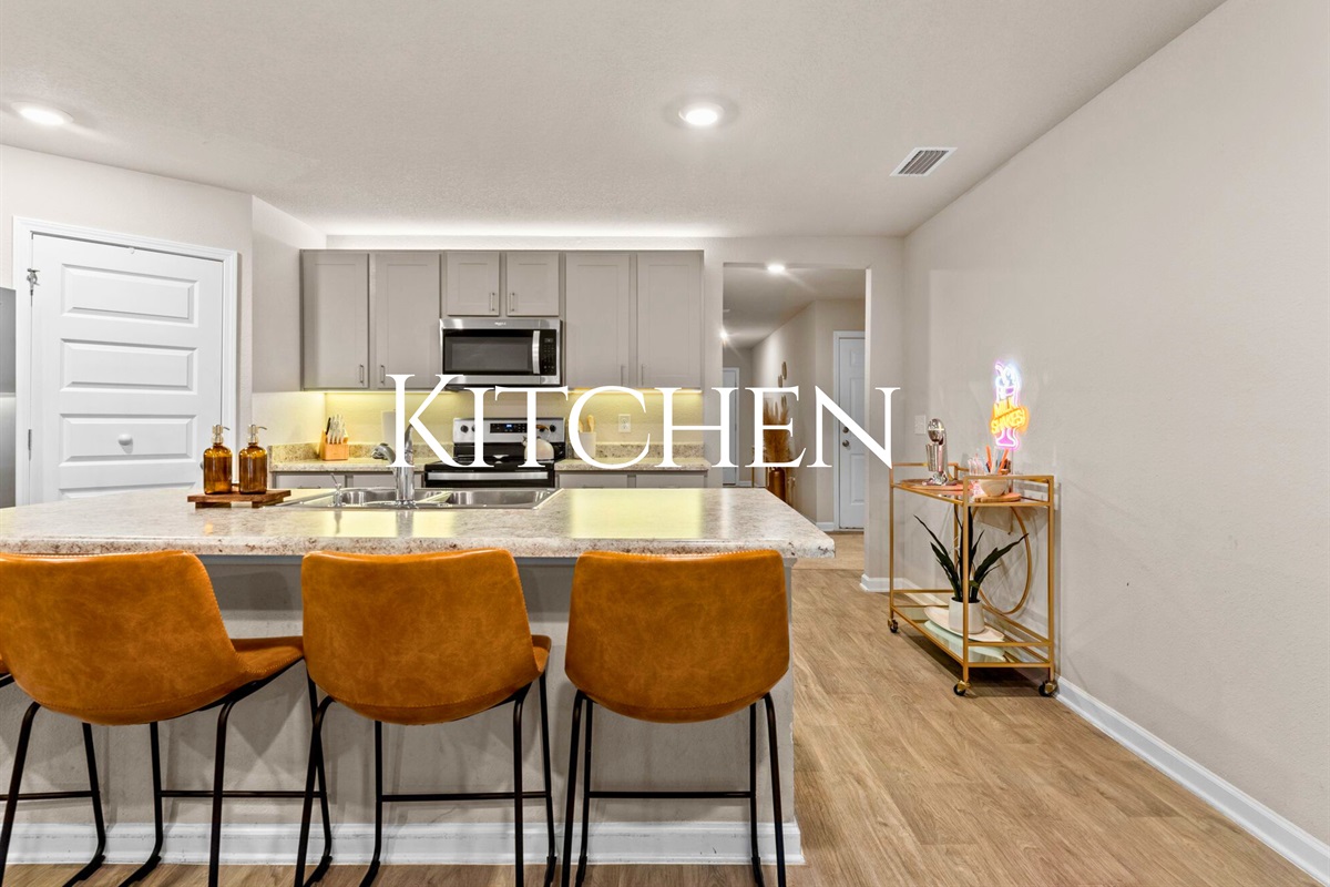 The kitchen is spacious and functional, with plenty of counter space and bar seating for casual meals or snacks.