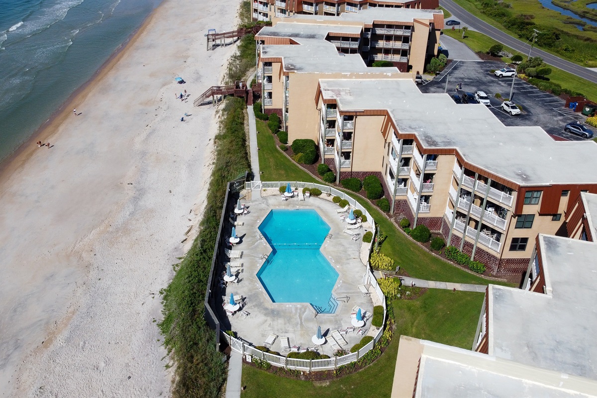 The pool is nestled between beach and the condos