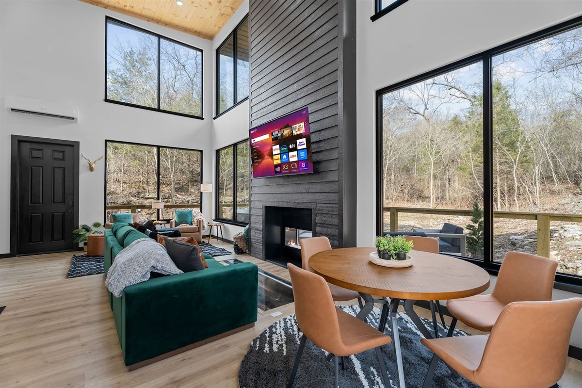 Main Living Area: Sunlit space with large windows, plush seating, and a stylish indoor-outdoor fireplace!