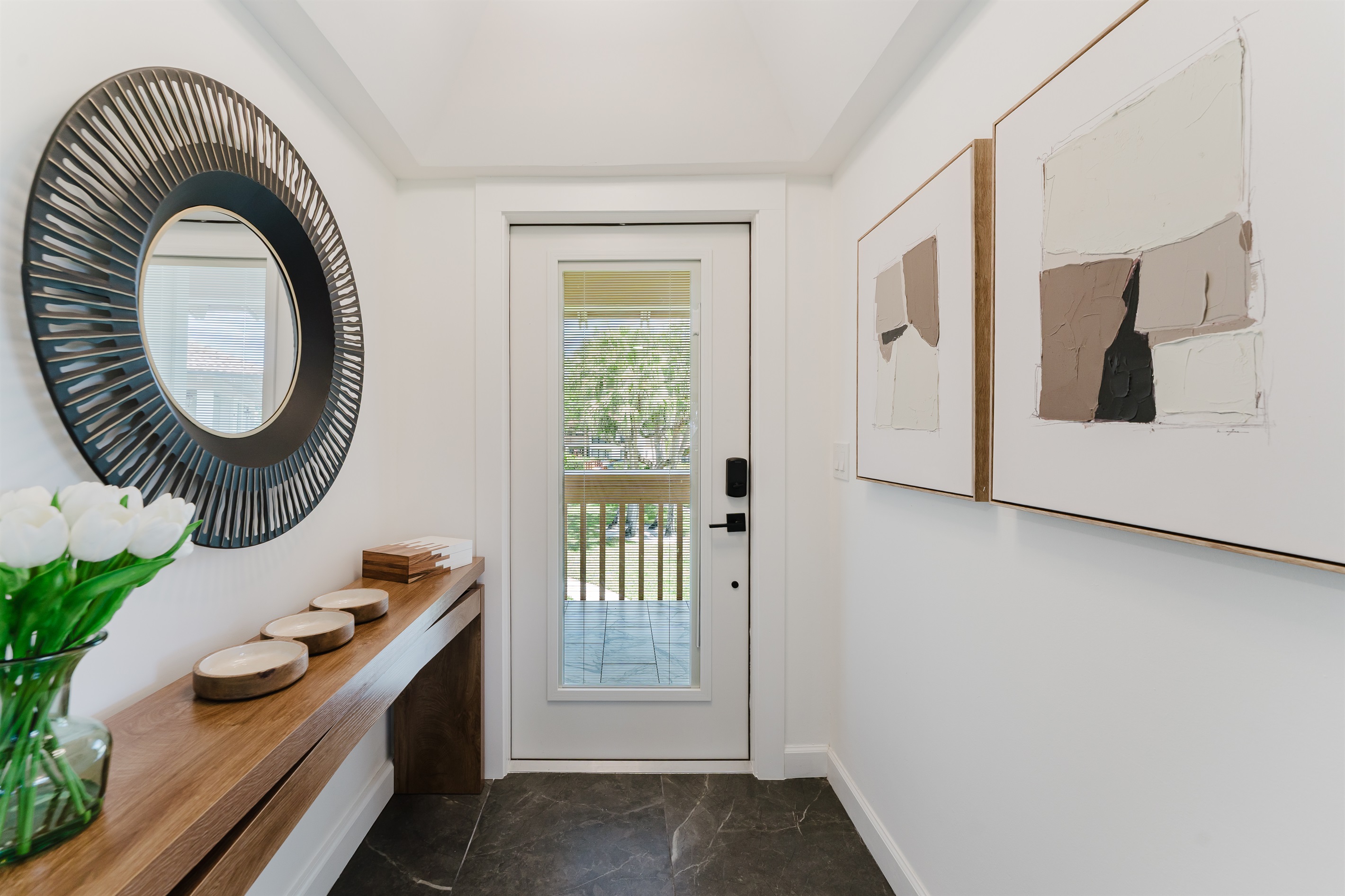 Stylish entry console with designer accents and a statement mirror, setting a warm and inviting first impression