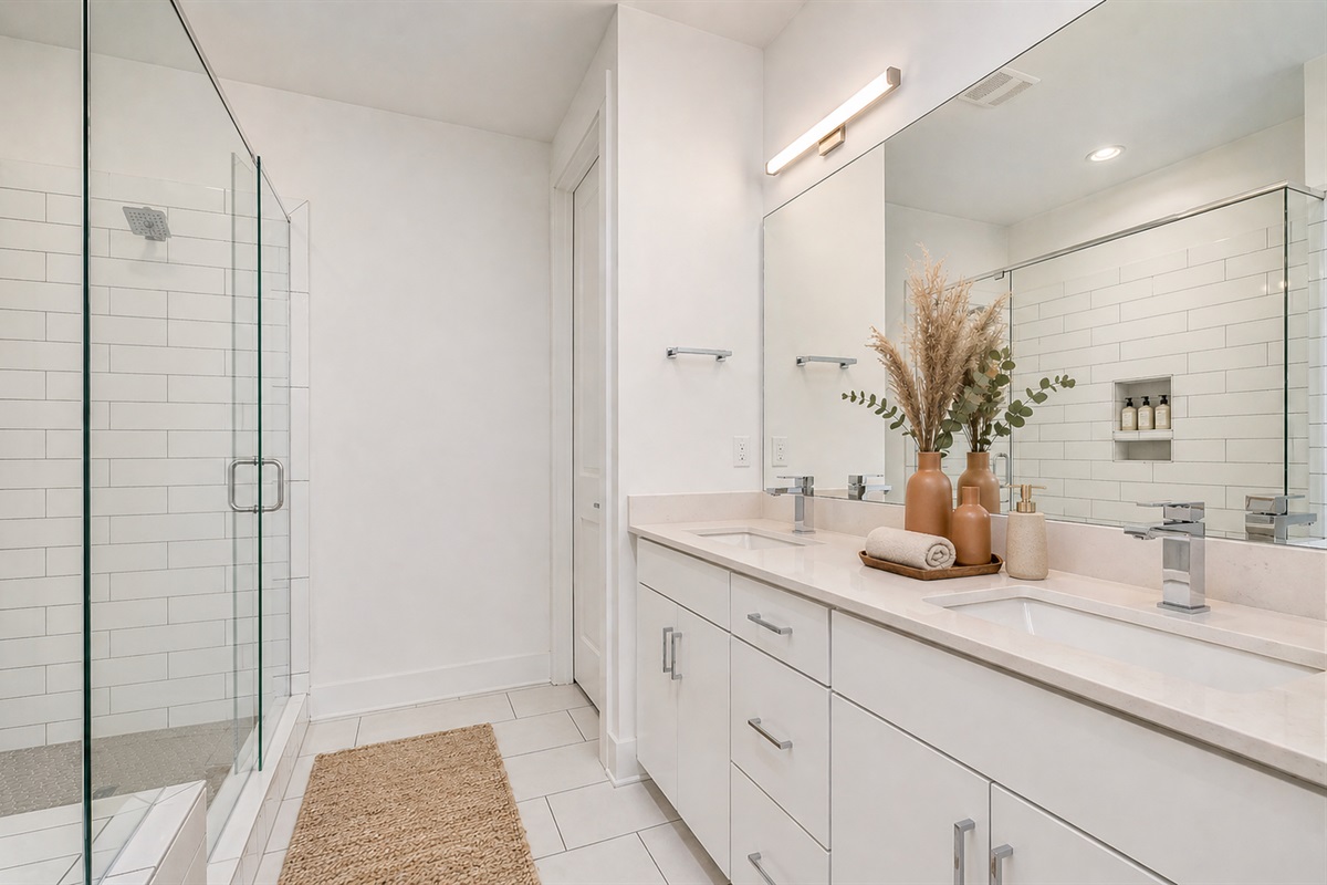 The spacious primary bedroom has its own ensuite bathroom. With double vanity and walk-in shower, the bathroom is an extension of your luxurious stay in Charlotte.