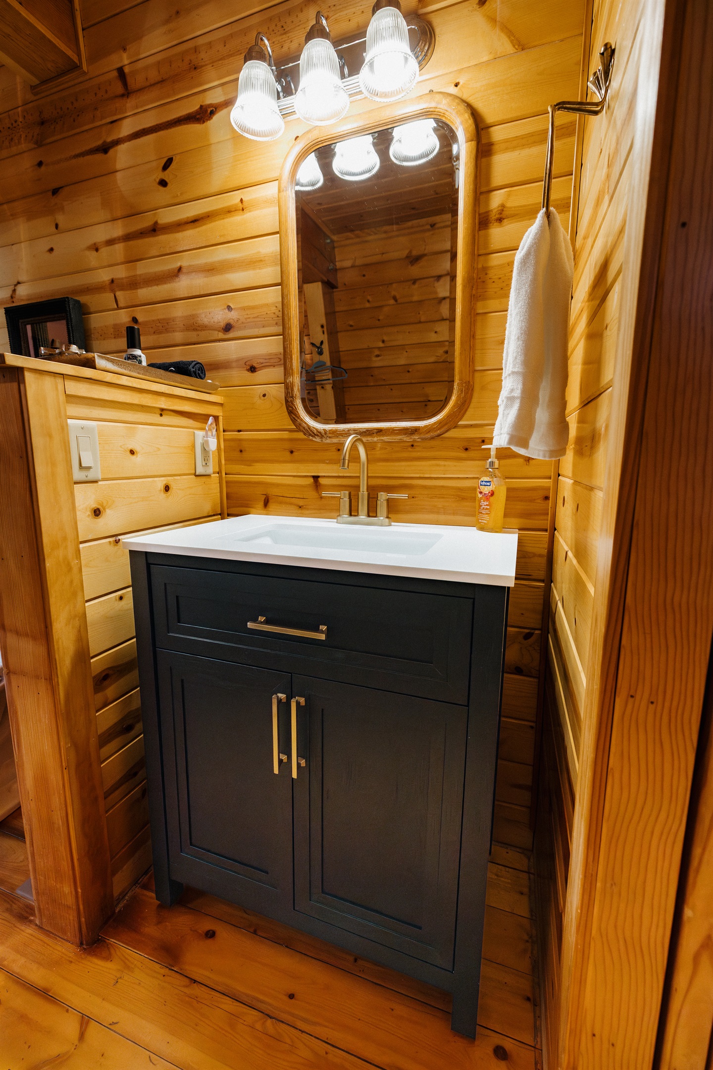 Poppywood Pines’ bathroom offers ample counter space and generous storage, featuring a stylish vanity, warm wood accents, and thoughtful design—perfect for getting ready comfortably during your relaxing White Mountains cabin stay.