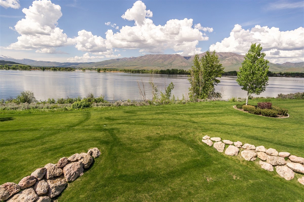 A beautifully landscaped green space framed by mountain and water views—your personal retreat just steps from the shoreline.