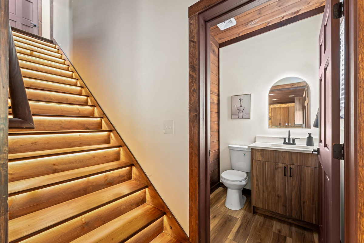 motion sensor stairs leading upstairs, featuring a half bath 