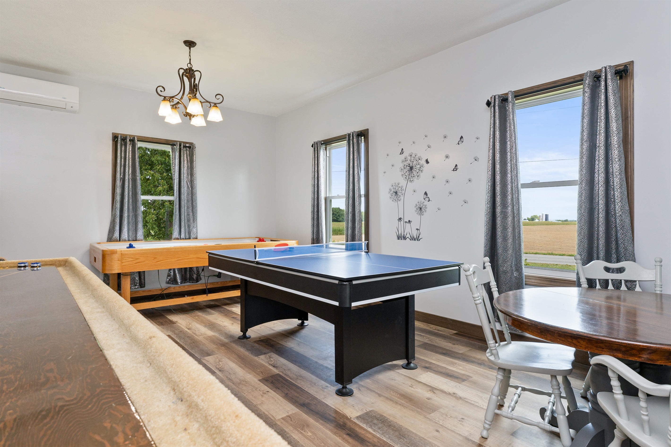 Entertainment-ready game room featuring a combination ping pong/pool table, shuffleboard, and air hockey with several board games and Cornhole for outside..... endless fun!