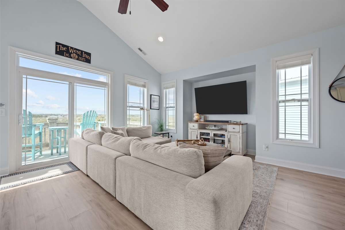 Relax in the open concept living area with an abundance of natural light, cozy seating, smart TV, and sound views