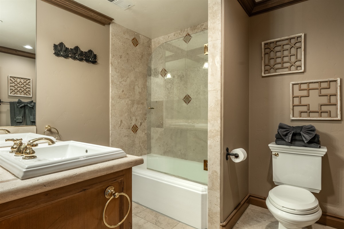 An en-suite primary bath with double vanity and tub/shower combo—designed for both comfort and easy shared use.