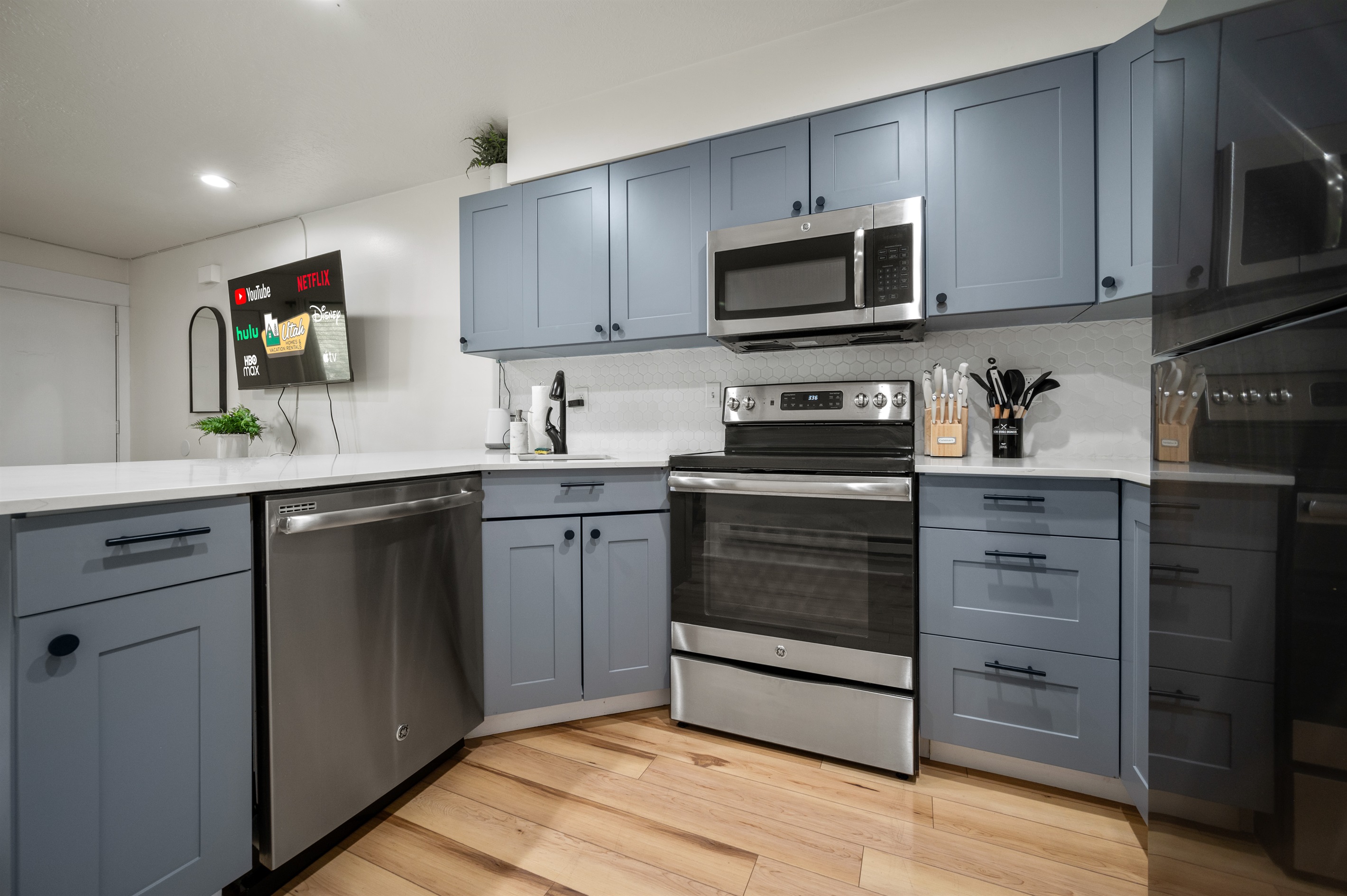 Sleek kitchen featuring stainless steel appliances and expansive quartz counters.