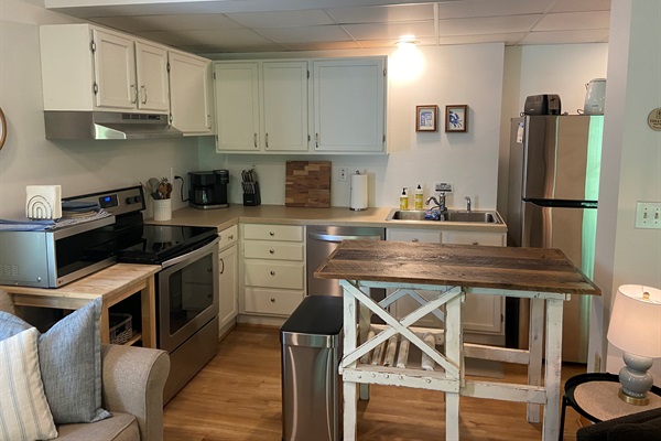 Kitchen includes full-sized appliances and extra counter space for meal prep and spreading out. The kitchen is well appointed for cooking a meal.