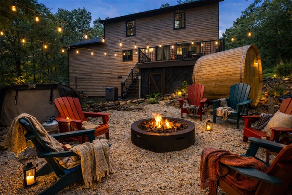 Step out the back door and your entire outdoor setup is right there — hot tub, fire pit, barrel sauna, and Adirondack chairs already waiting for you.