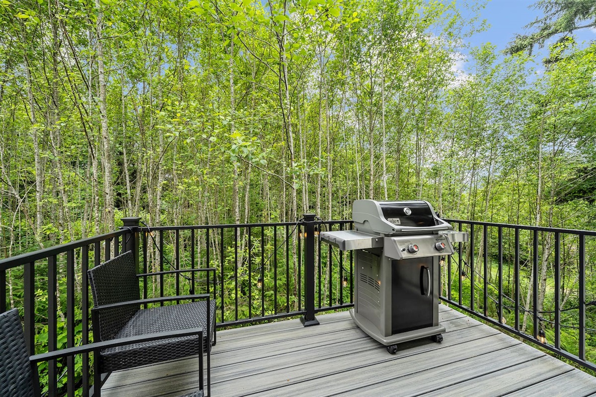 Balcony with outdoor chairs and a Weber BBQ 
