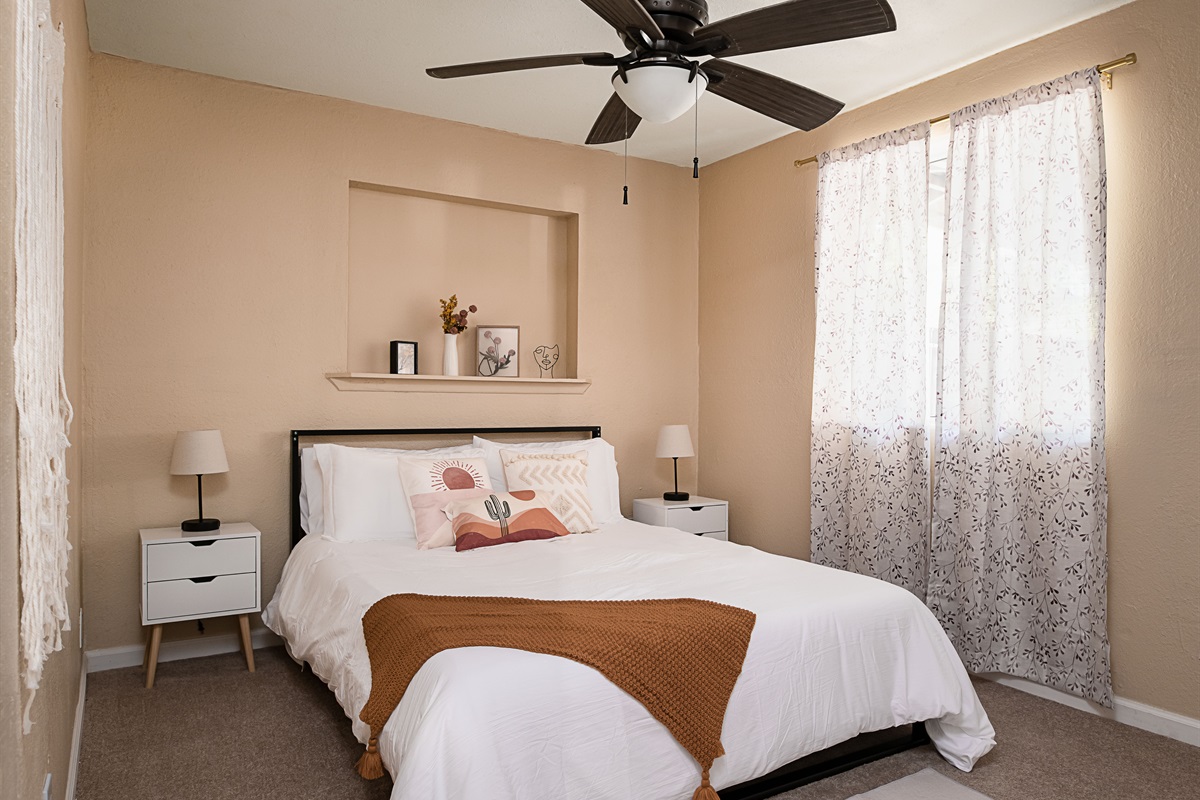 Chic and cozy, this sun-filled bedroom features soft neutrals, modern decor, and a peaceful ambiance perfect for a restful night's sleep.