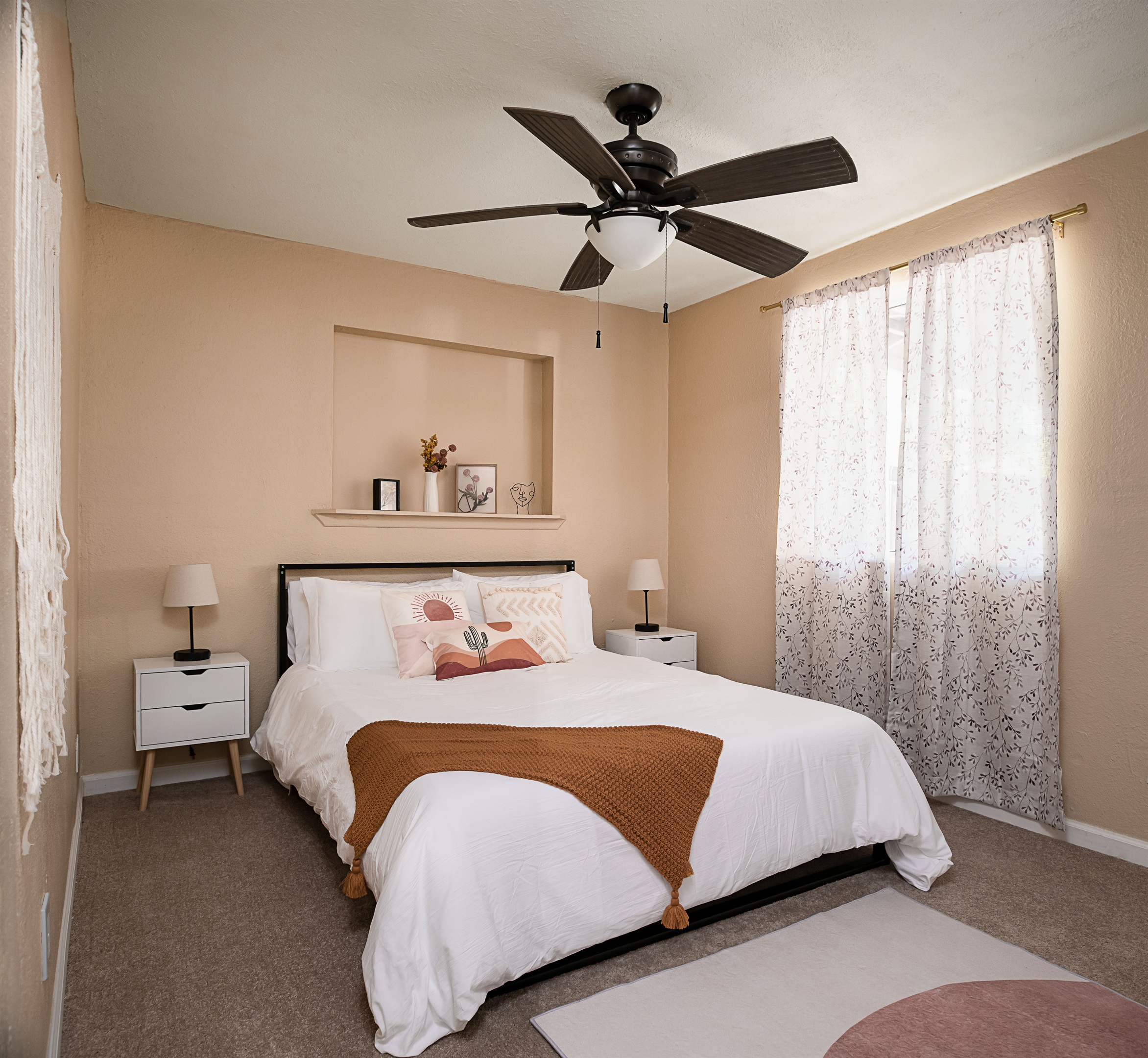 Chic and cozy, this sun-filled bedroom features soft neutrals, modern decor, and a peaceful ambiance perfect for a restful night's sleep.