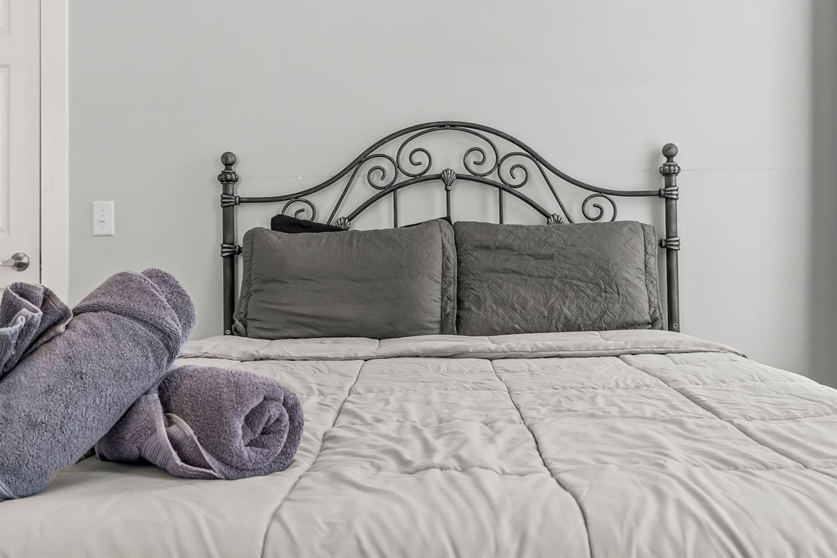 Centered bed view with neatly folded towels, creating a calm and restful sleeping atmosphere.