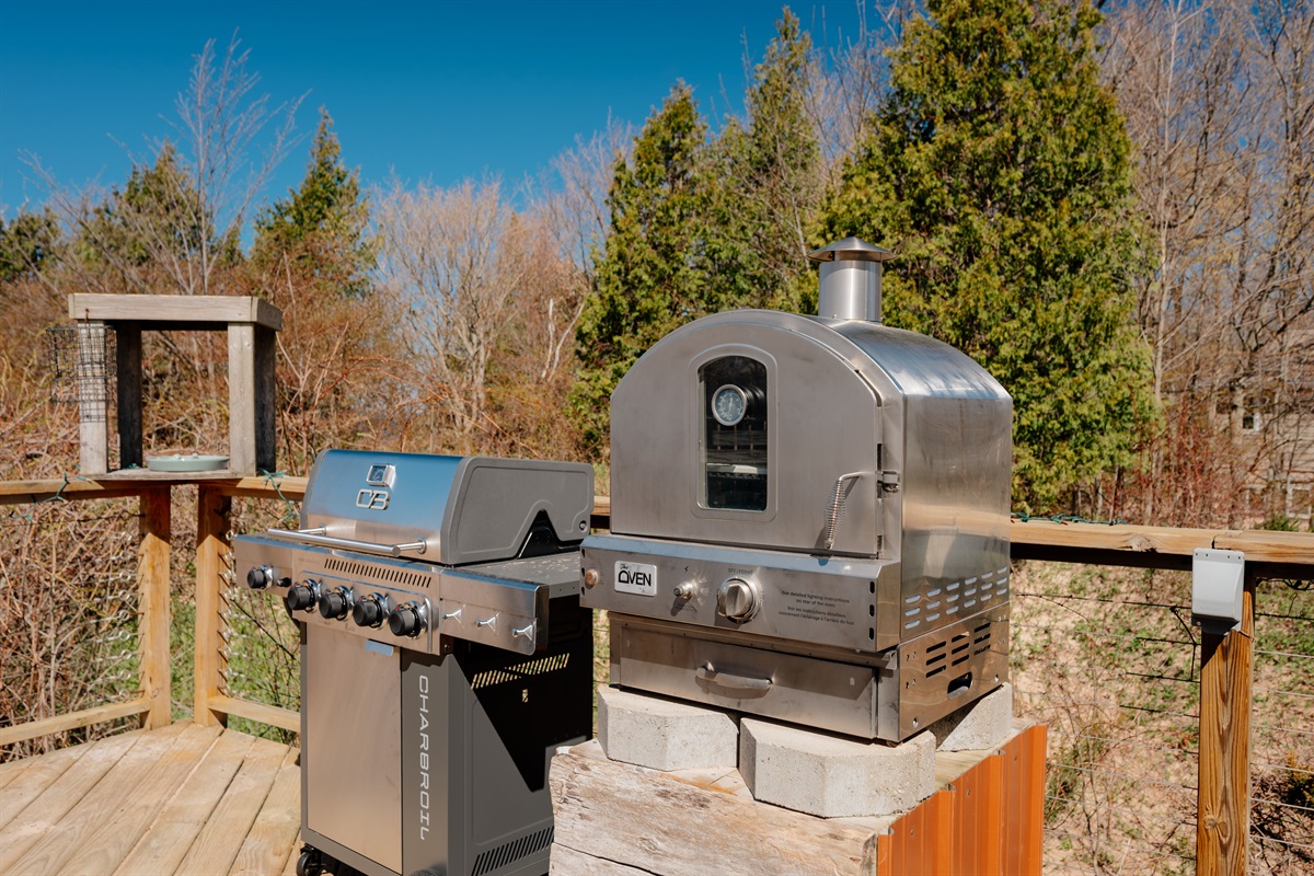 Outdoor cooking area featuring a propane grill and pizza oven, perfect for enjoying meals and entertaining on the spacious deck.