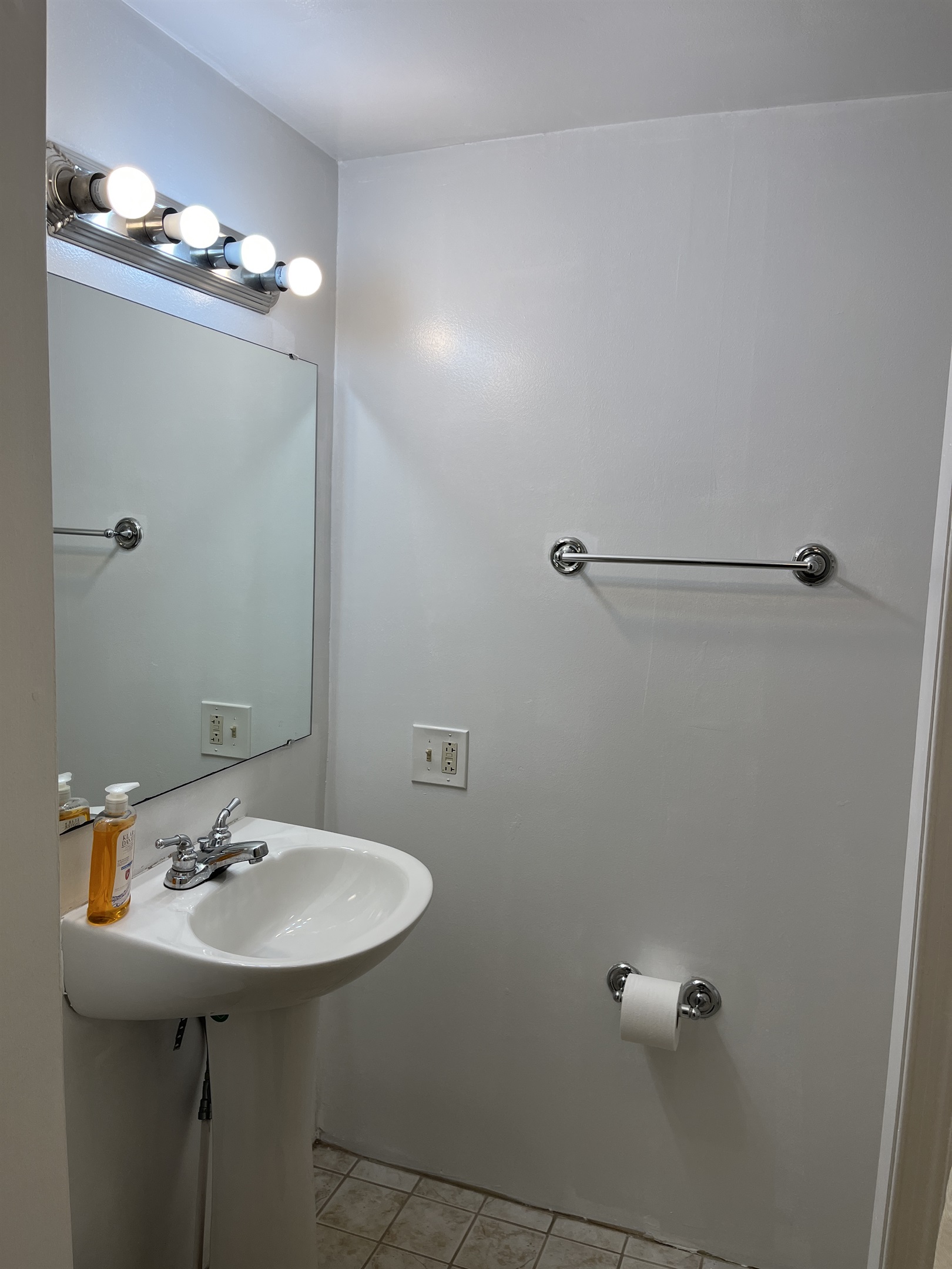 Full bathroom with shower located in corner of kitchen next to the laundry area.