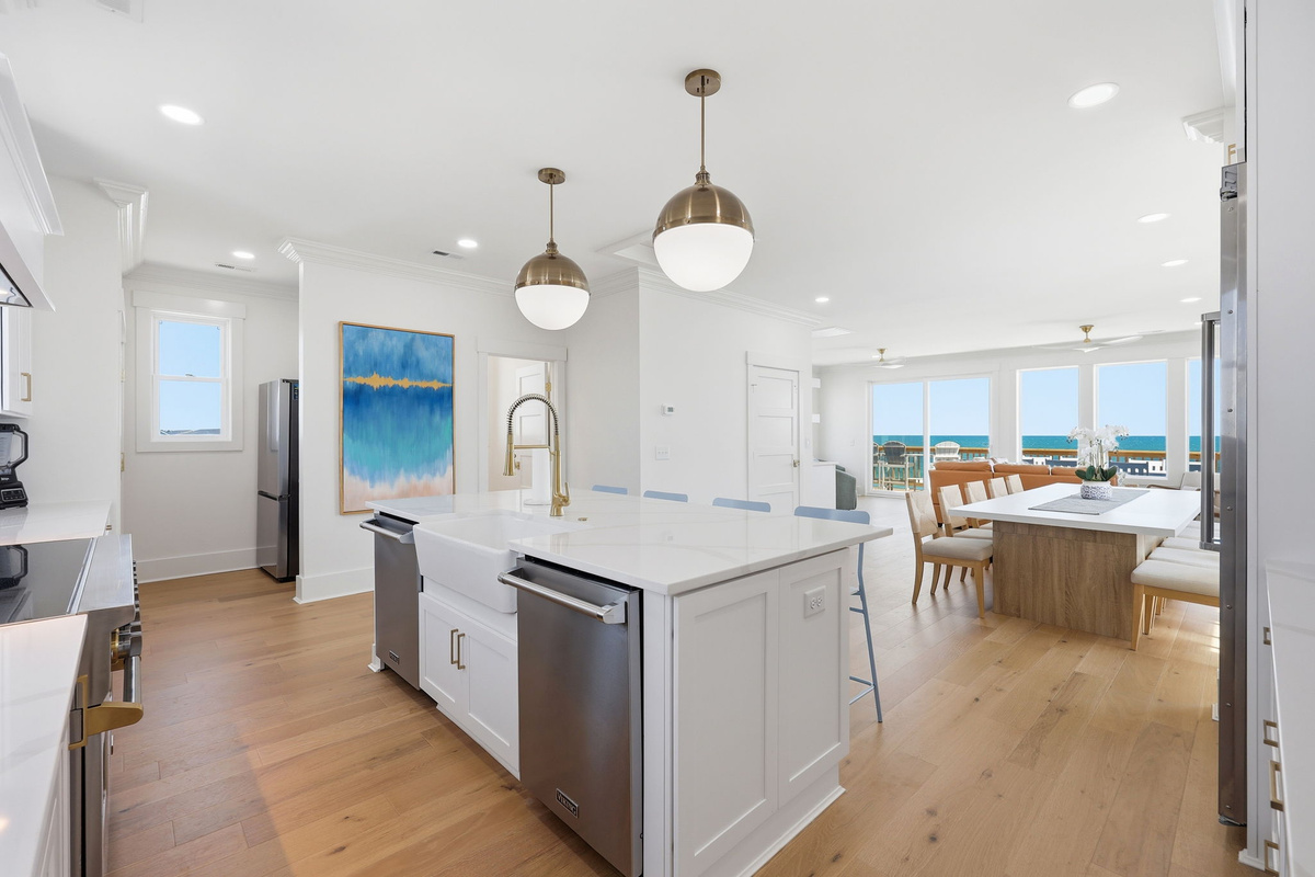 Another elegant kitchen perspective highlighting the island workspace and open coastal layout