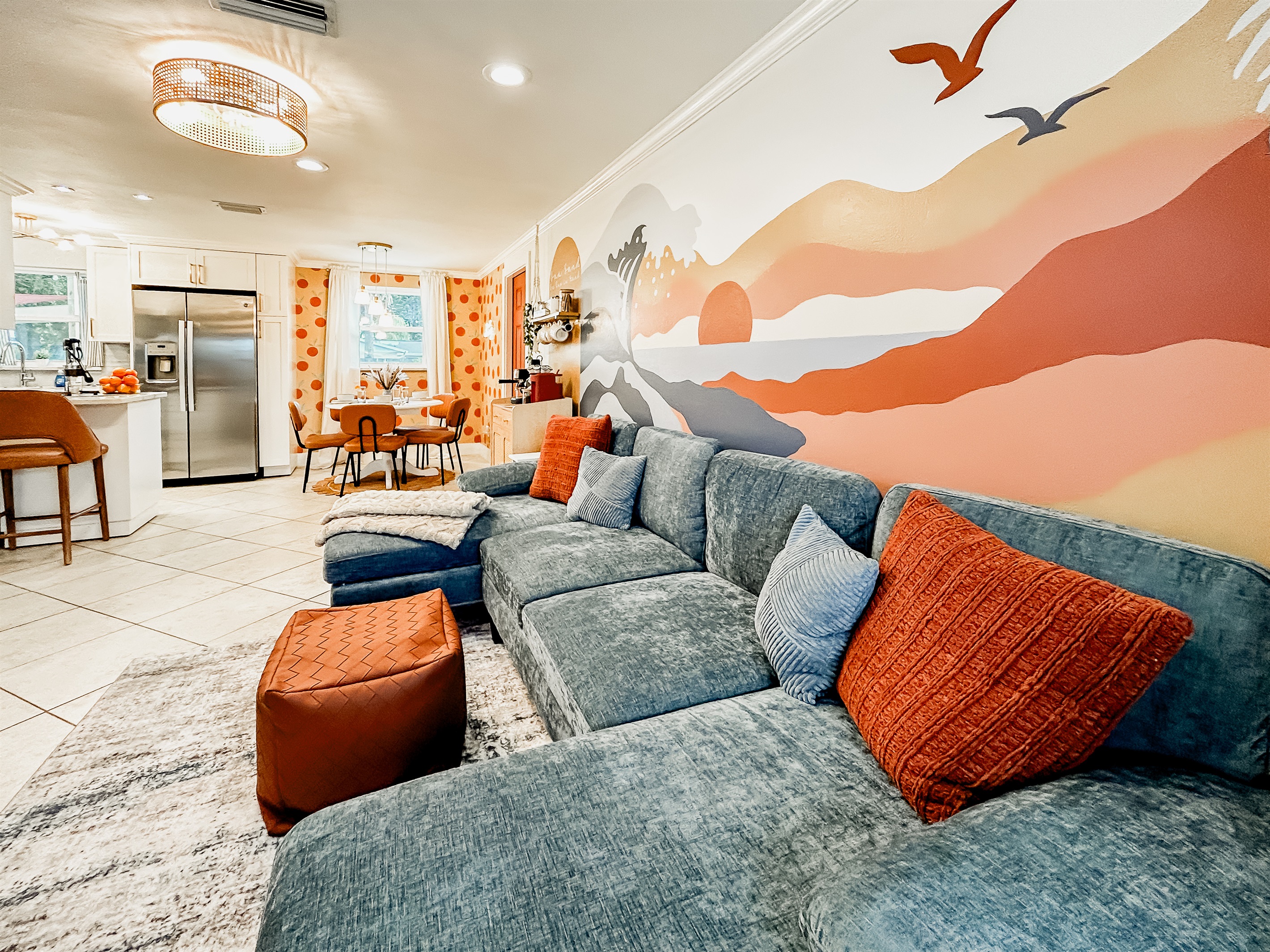 Living Room with Couch, 65" Roku TV, Indoor Electric LED Fire Place, Fandelier & Local Artist Mural