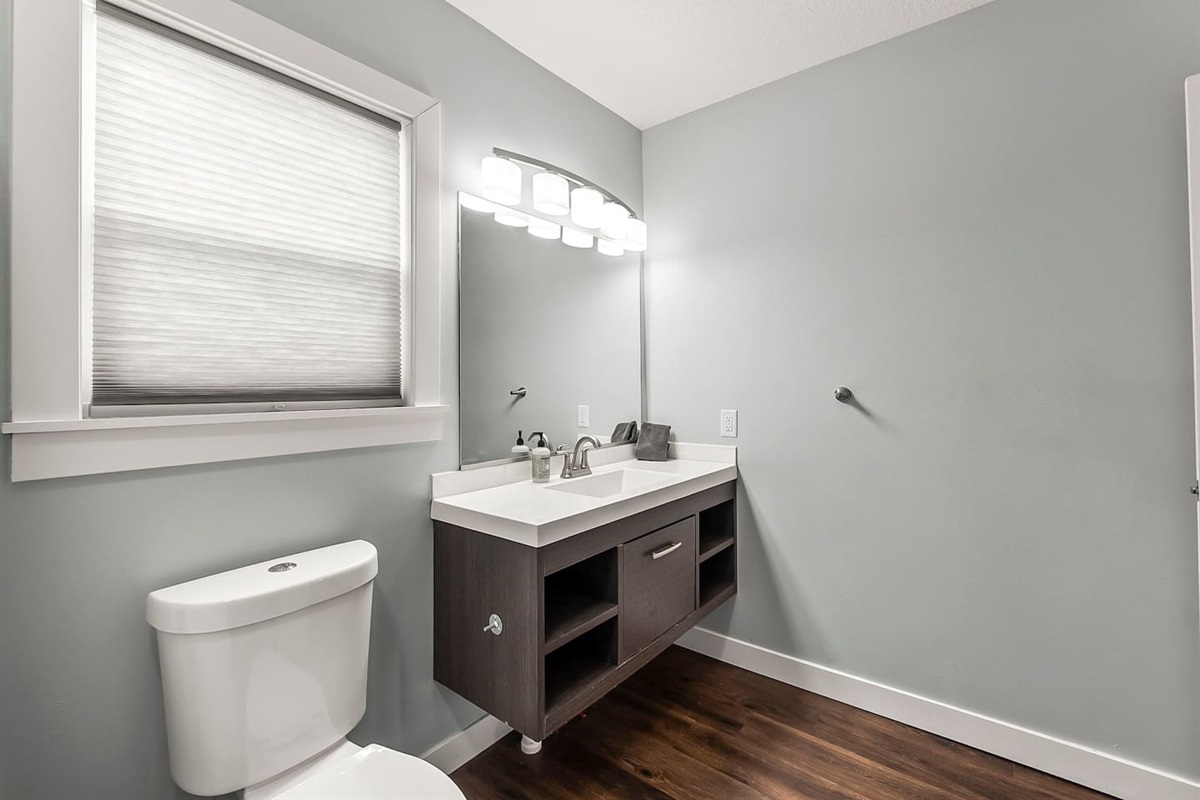 Clean vanity area with large mirror, contemporary lighting, and plenty of counter space for daily routines.