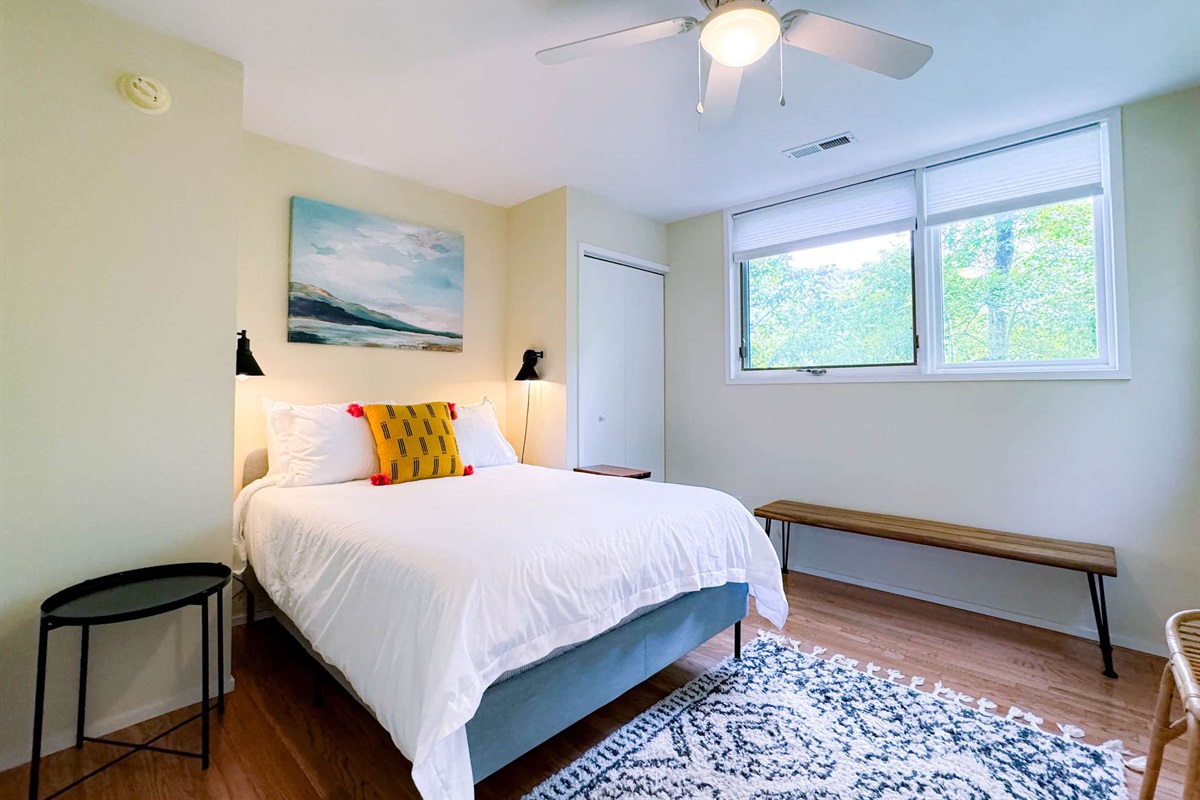 Comfy full size bed with an abundance of natural light. Enjoy the all natural tree art pictured in the windows!