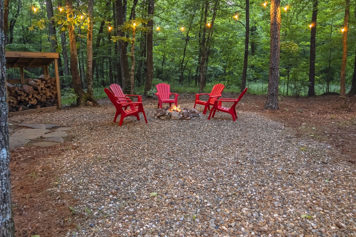 Firepit area surrounded by string lights under the night stars.
