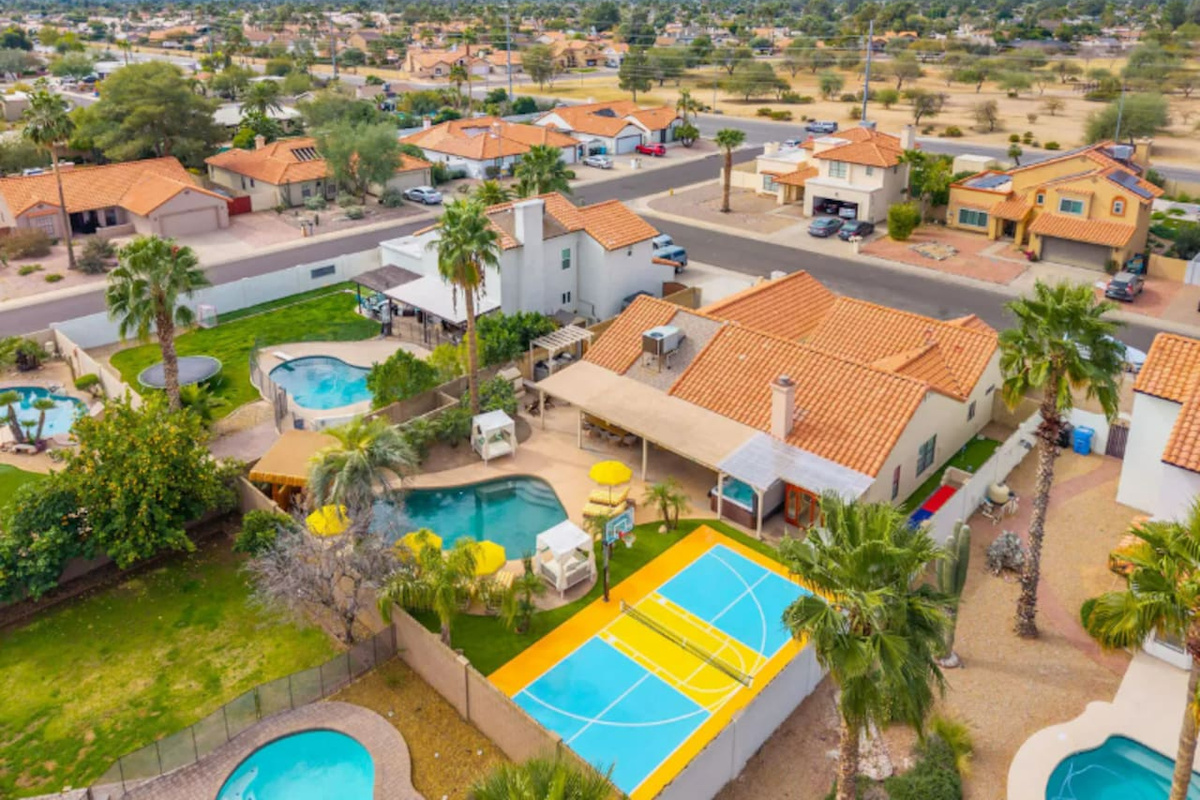 Aerial view of property with pools, sports courts, and desert mountain views—a premier Scottsdale vacation home with resort-style amenities.