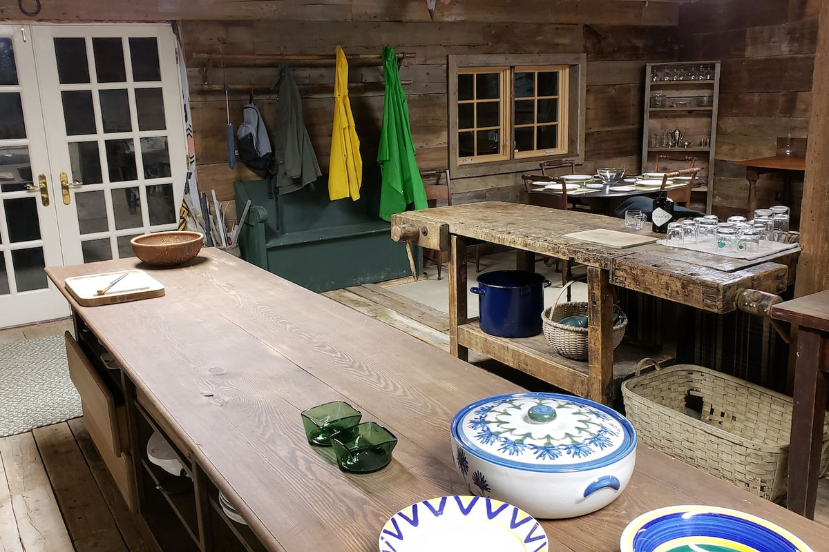 French door entry, antique coat rack, church pew bench  and hefty authentic farmer's work bench bar.
