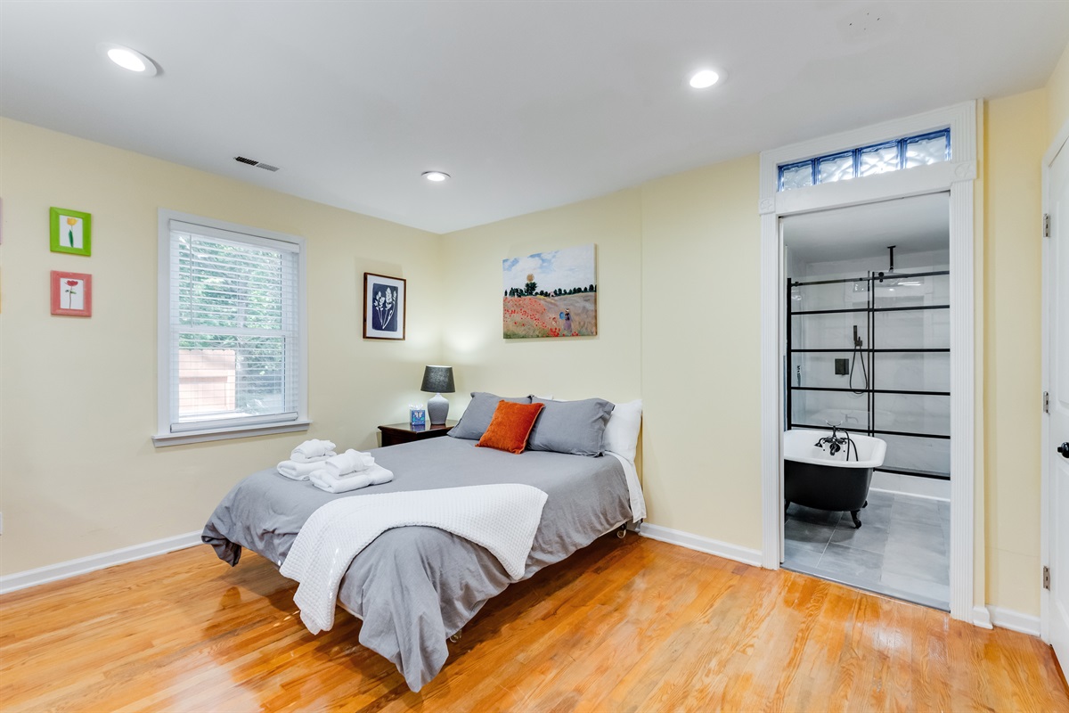 Upstairs Queen Bedroom 2: Bright space with artful decor, a comfy bed, and stylish ensuite bath!