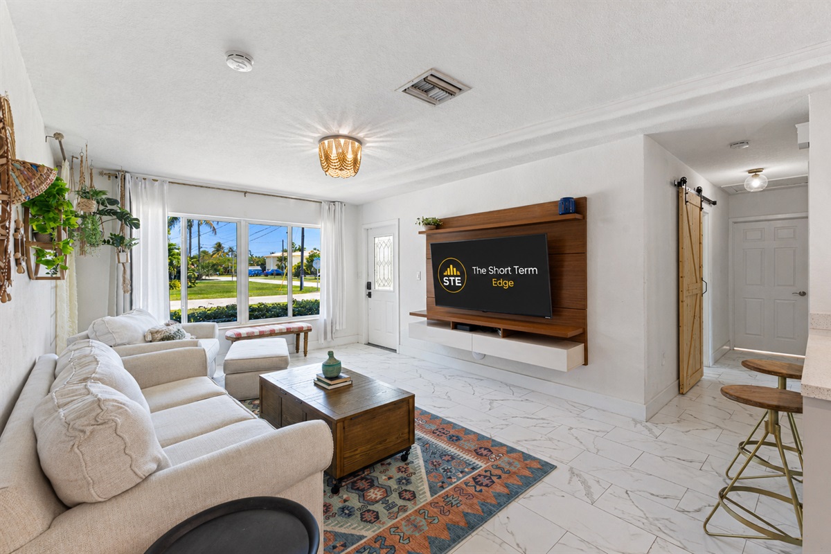 Bright, open living room with a 60" Smart TV — perfect for relaxing.