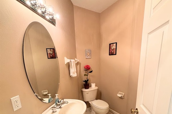 Convenient half bathroom with pedestal sink, tile flooring, and clean neutral finishes.