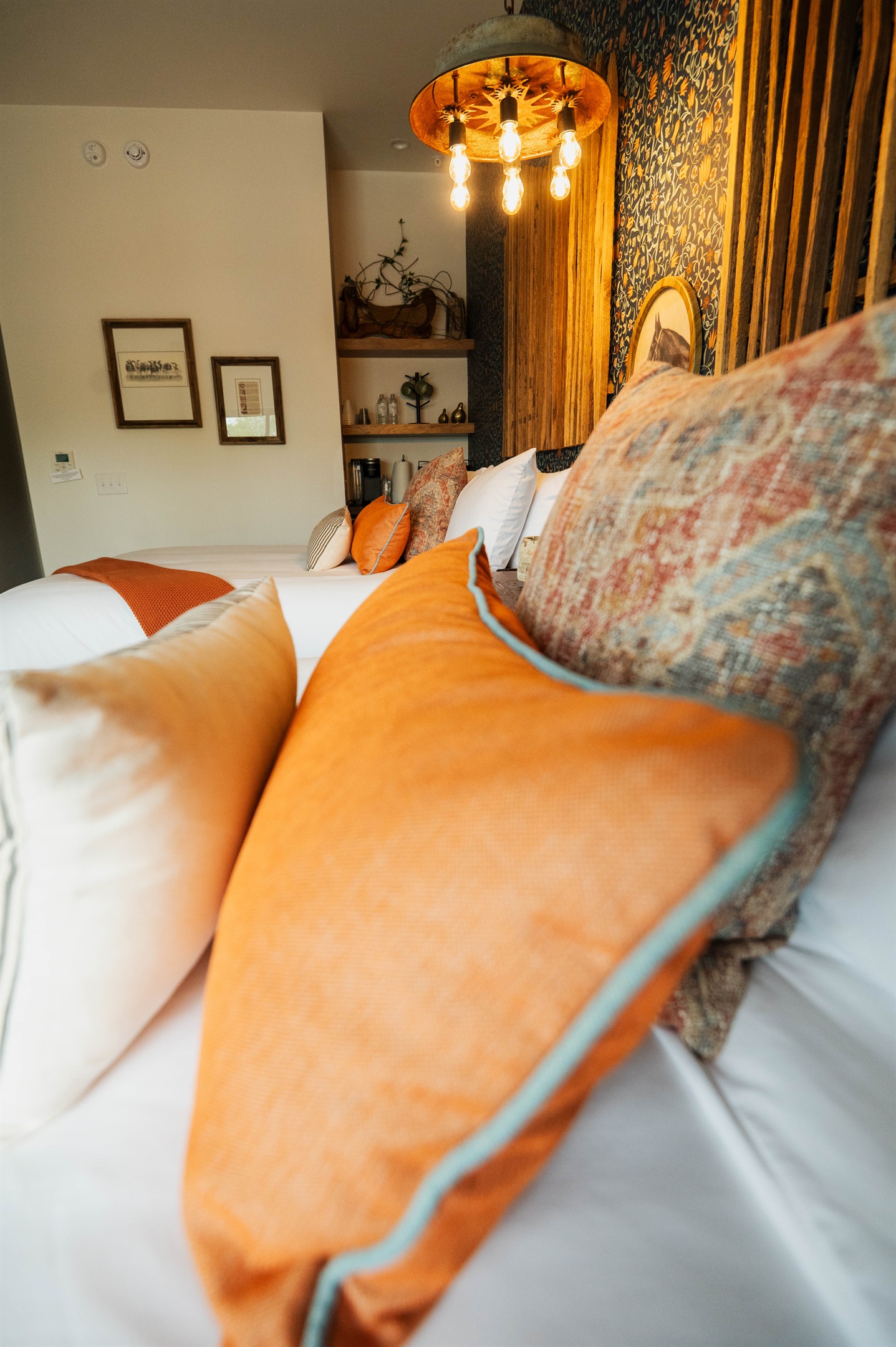 The Corral Suite from a fresh angle — two queen beds, designer pendant lighting, and the property's signature feature wall.
