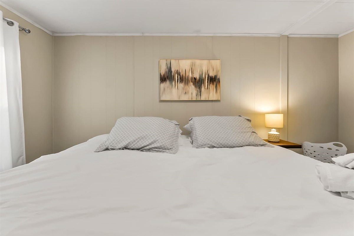 Warm and inviting bedroom décor, featuring calming neutral tones and modern artwork.