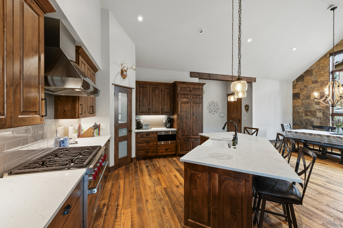 Kitchen with cabinet-matching refrigerator doors, walk-in pantry, island with bar seating, lots of counter space and Wolf range. 