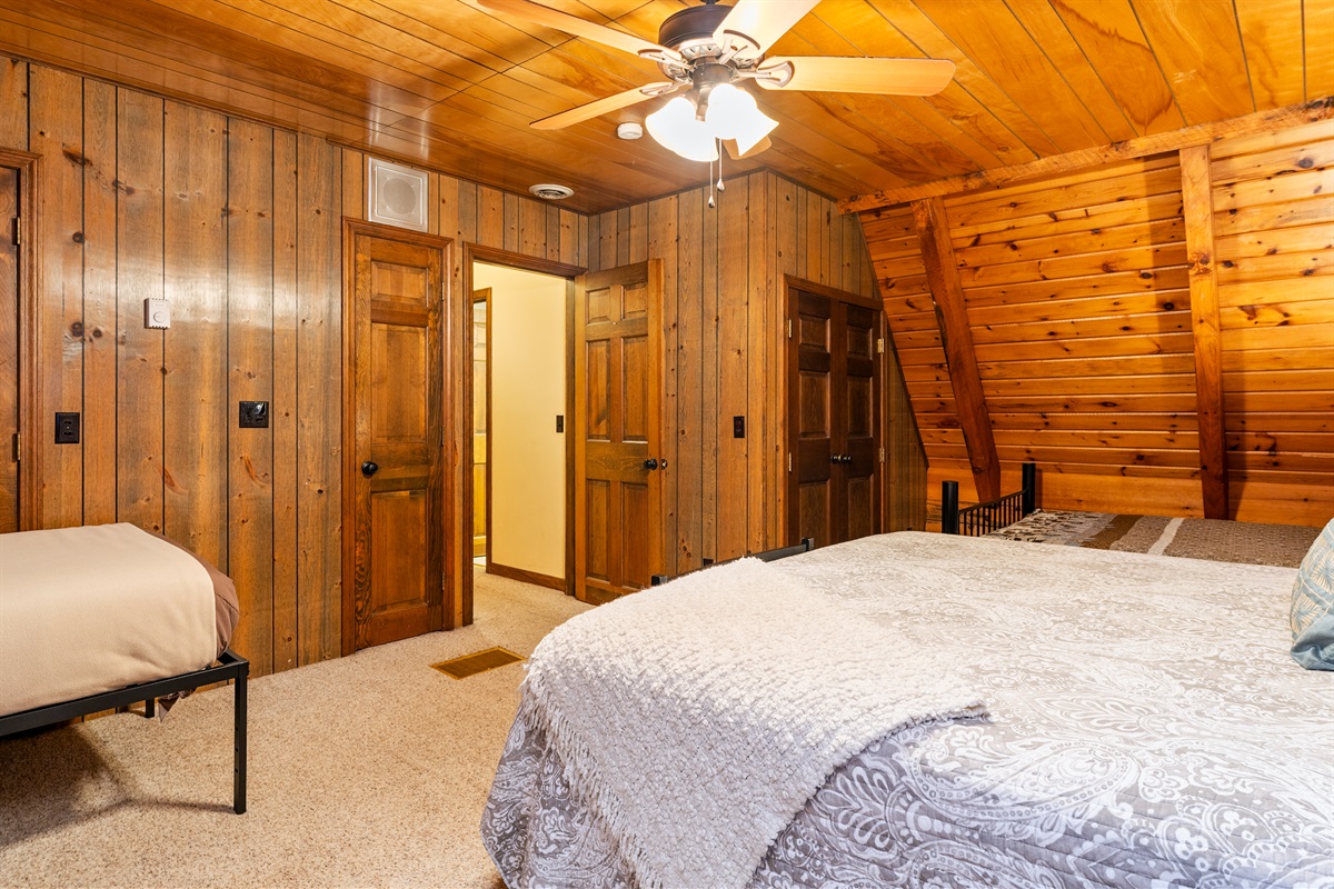 Bedroom #4 Inviting bedroom with a King, 2 double beds and an additional twin, rustic wood walls, and a comfortable, homey atmosphere.