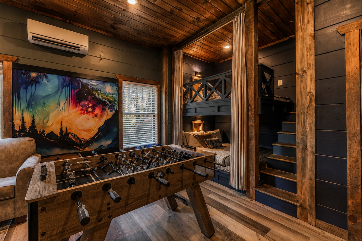 This cozy bunk room has a fun mural, foosball and incredible Queen bunks.