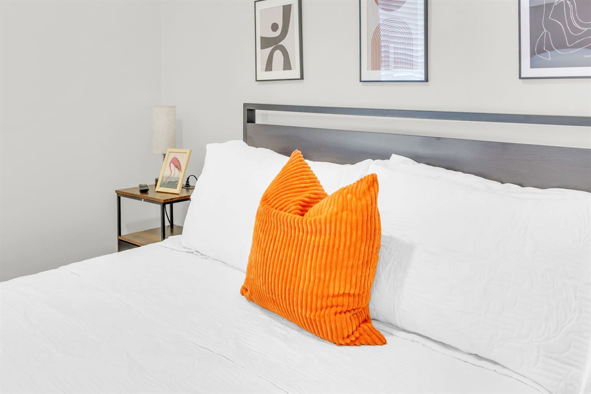 Bedroom with cozy queen bed, plush bedding and fresh decor.