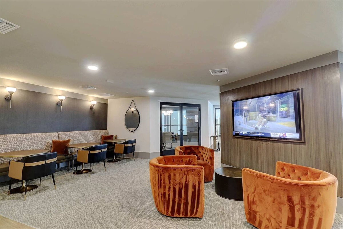 - Enjoy a comfortable lounge area with cozy chairs and large flat-screen TV   - Perfect for watching your favorite shows, meetings, or casual hangouts   - Modern lighting, soft seating, and warm tones set the relaxing mood