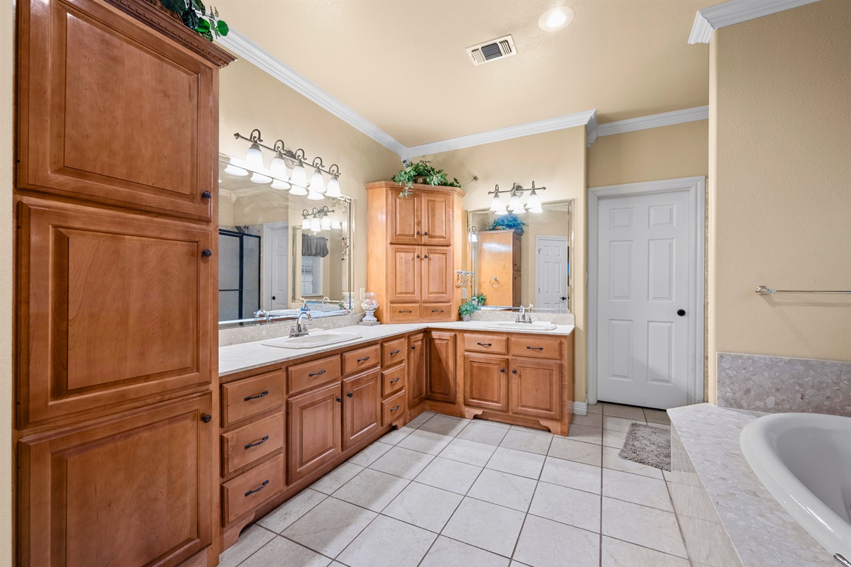 Large ensuite bath with double sinks and tile flooring.