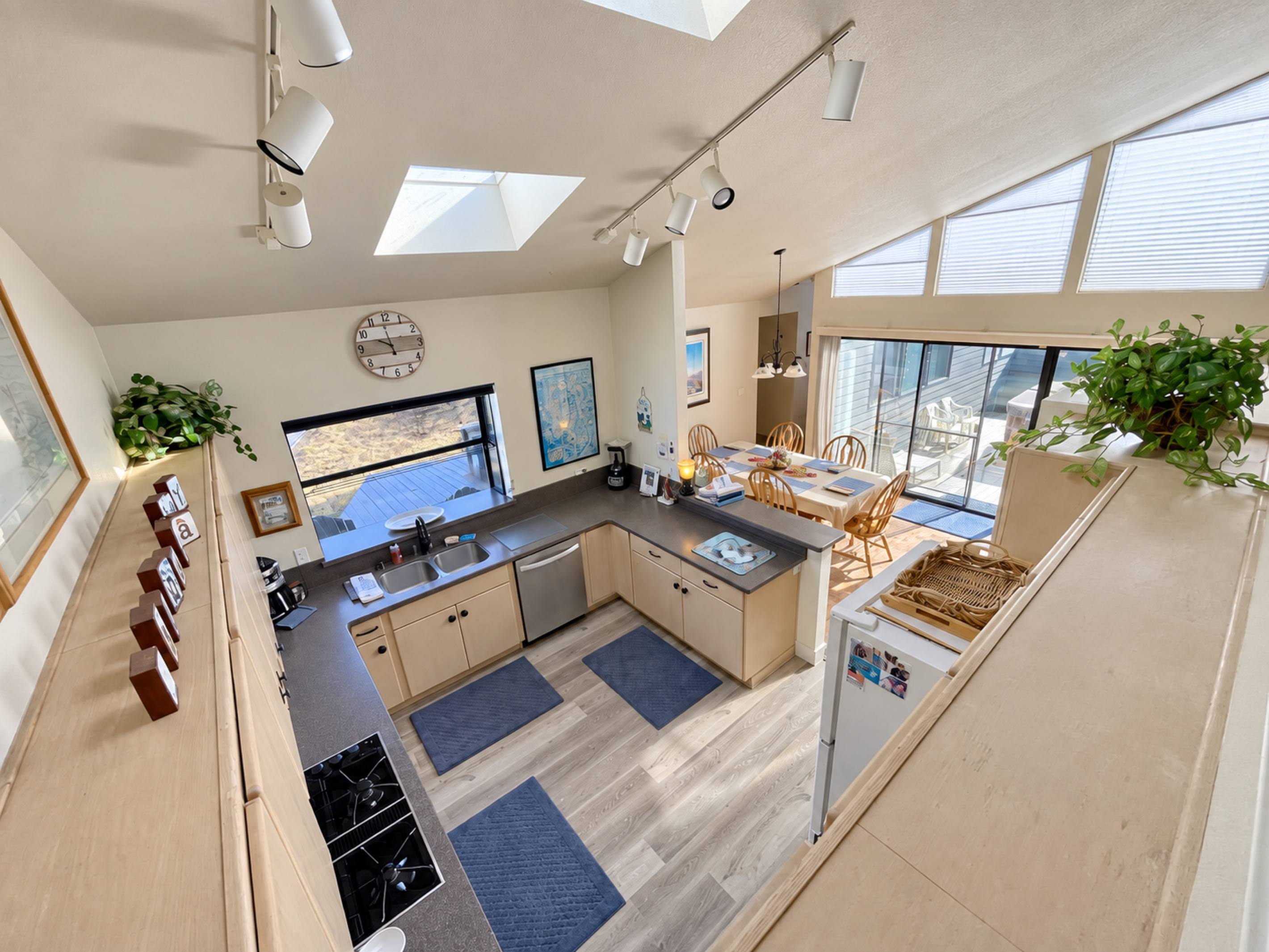 Open Floor plan from Living Room upstairs. Looking down on kitchen and dining area. Natural lighting from vaulted ceilings and skylight windows.