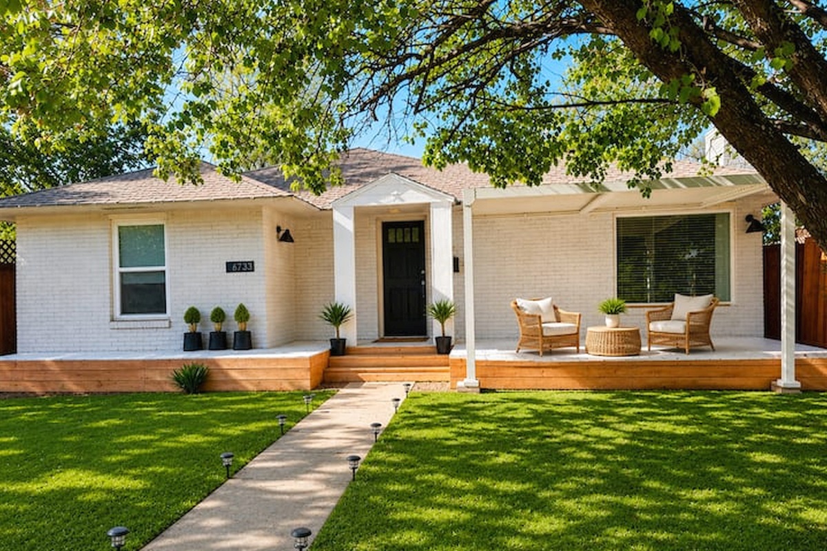 Charming modern home with inviting front porch seating, fresh landscaping, and a warm boutique-style welcome