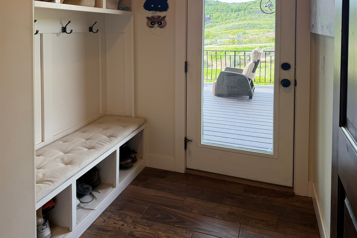 Functional mudroom with bench seating, storage, and direct access to the deck and outdoor living spaces.