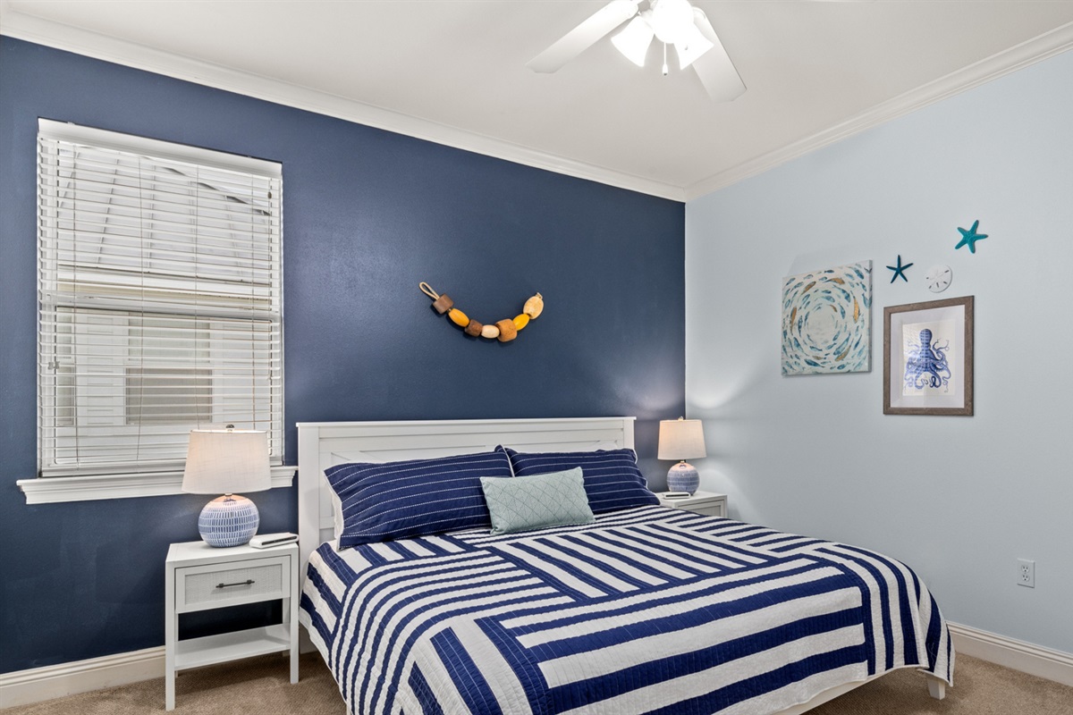 A king bed in crisp navy stripes with coastal touches that whisper "sleep in.