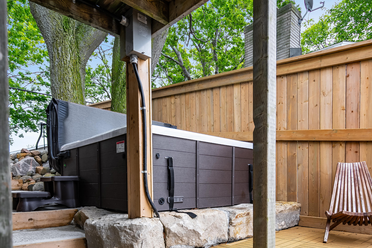 Modern outdoor hot tub nestled in a private, tree-lined backyard.